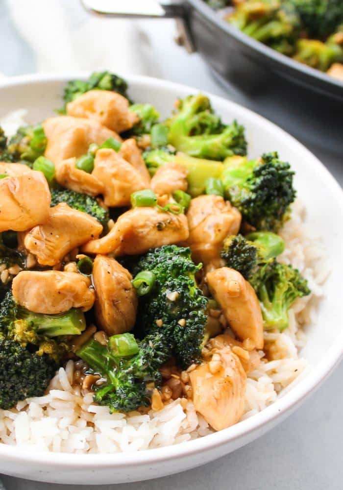 A white bowl of Teriyaki Chicken & Broccoli over white rice.